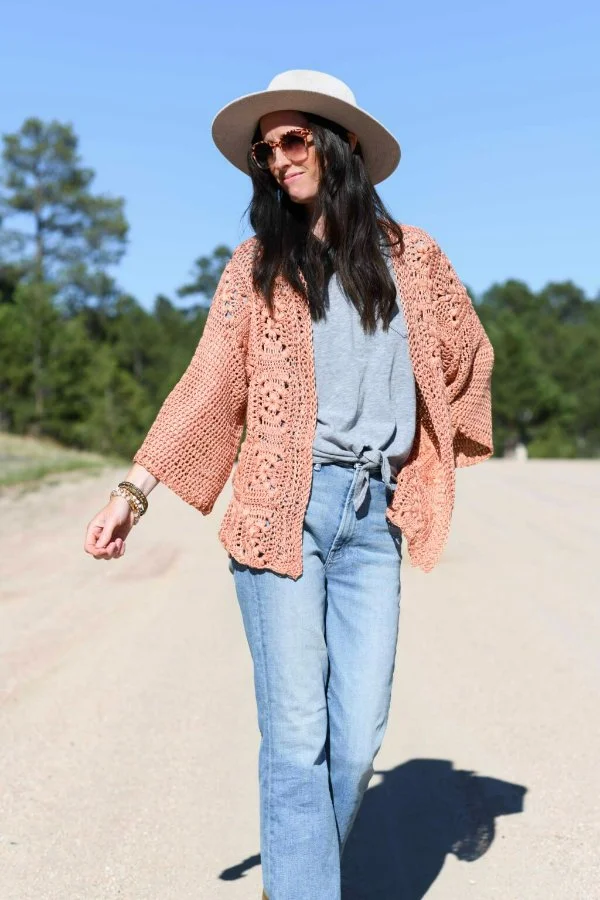 A woman wearing a boho-style crochet Granny Square crdigan with jeans.