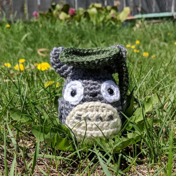 A little grey totoro amigurumi in a garden
