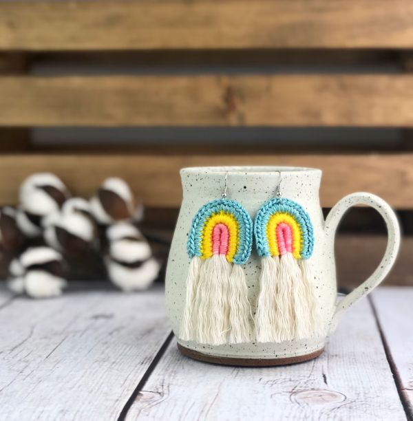 Rainbow-themed crochet earrings with tassels.