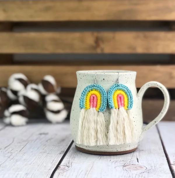 Rainbow-themed crochet earrings with tassels.