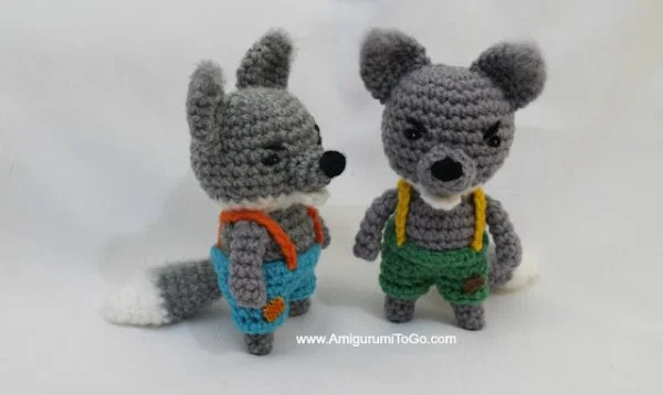 Two crochet wolf toys dressed as the big bad wolf from the Three Little Pigs.