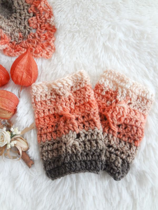 A flat lay image of cable crochet wristwarmers in beautiful autumn colours.