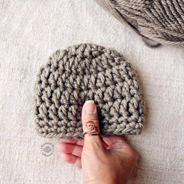 A tiny grey crochet baby beanie.