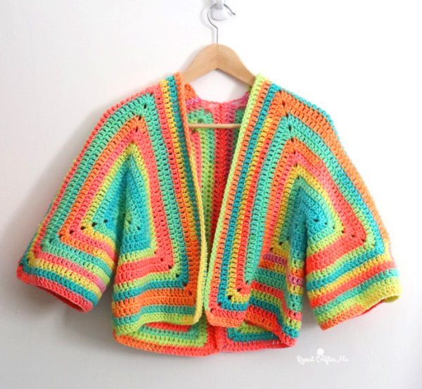 A neon-bright striped crochet hexagon cardigan on a wooden hanger.