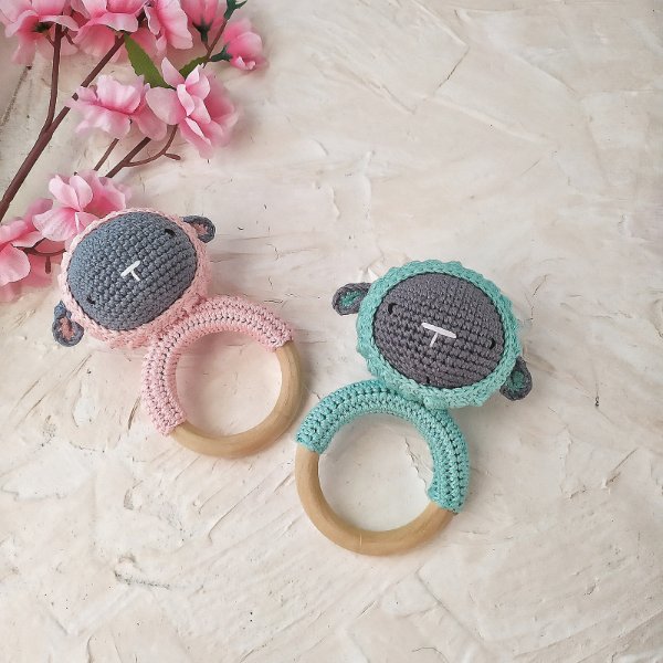 Two crochet sheep rattles on wooden rings.