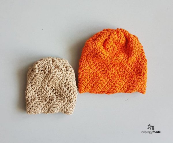 Two textured crochet baby hats in different sizes and colours.