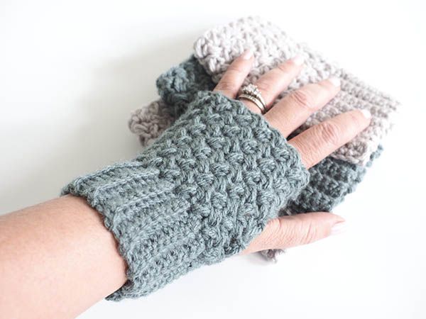A stack of grey and white crochet fingerless gloves.