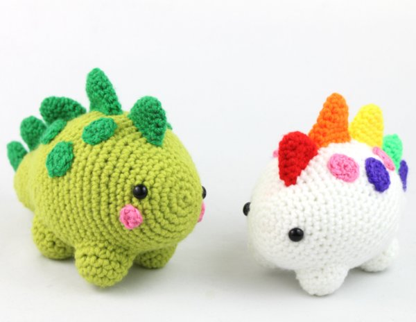 Two chubby crochet dinosaur toys.