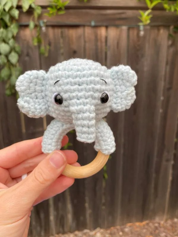 A close up image of a grey crochet elephant teething ring.