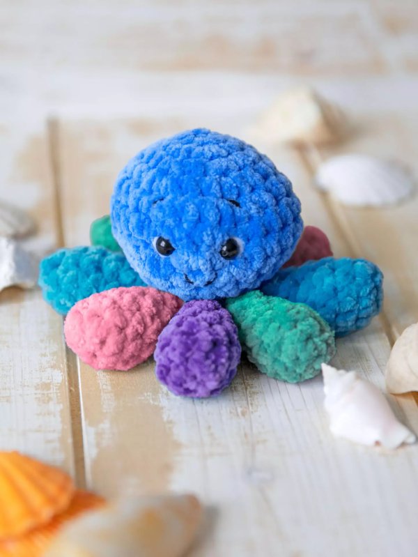 A brightly coloured octopus plushie made in chenille velvet yarn.