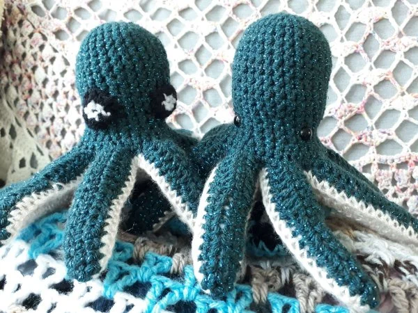 A pair of blue and white crochet octopus toys.