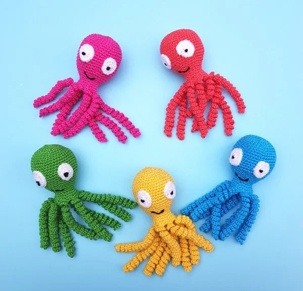 Five different coloured crochet octopuses for newborns.