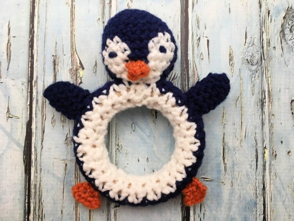 A crochet penguin baby rattle.
