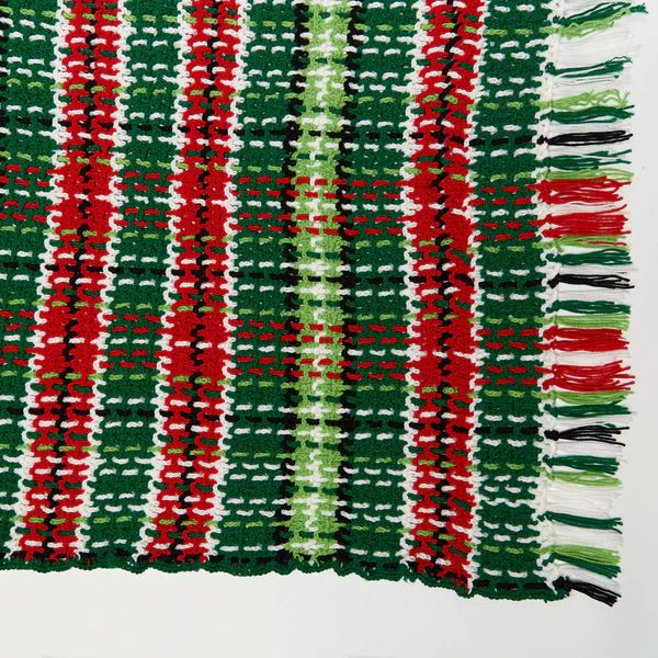 Green, red, and white plaid crochet christmas blanket with fringing.