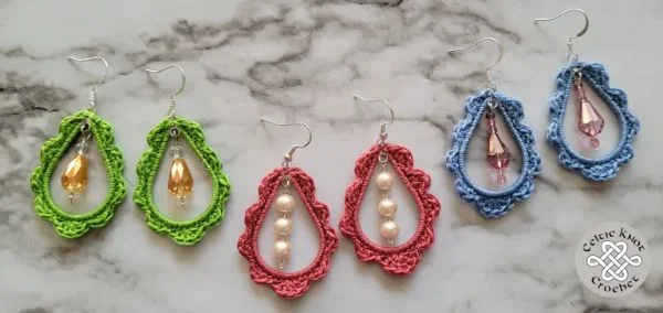 Three pairs of coloured crochet earrings with dangly beads.