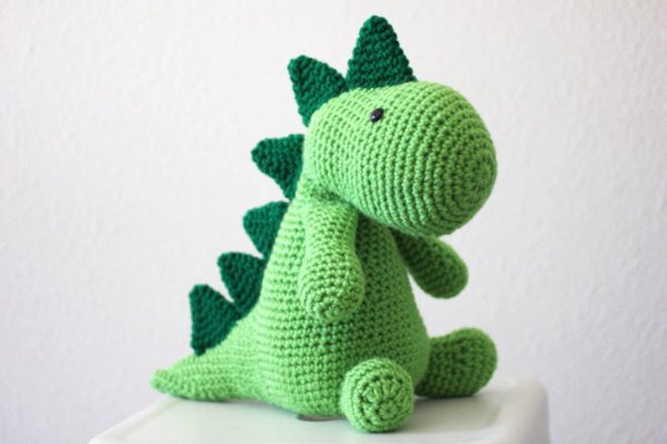 A green crochet dinosaur with dark green spines.