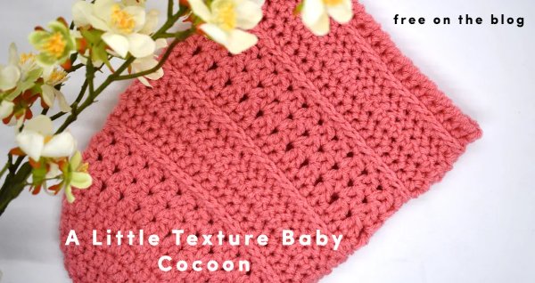 A flat lay image of a textured crochet baby cocoon.