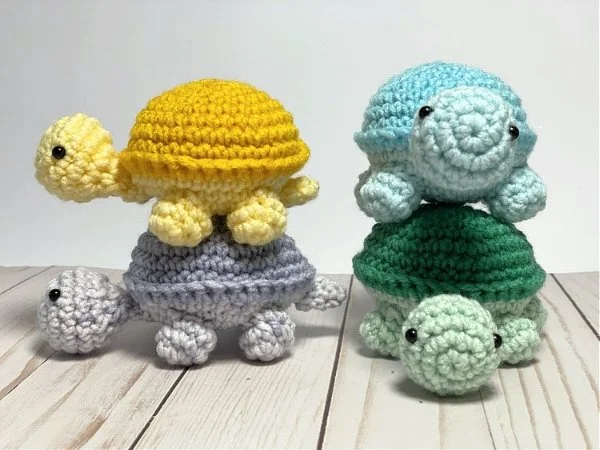 Four tiny crochet turtles stacked on top of each other.