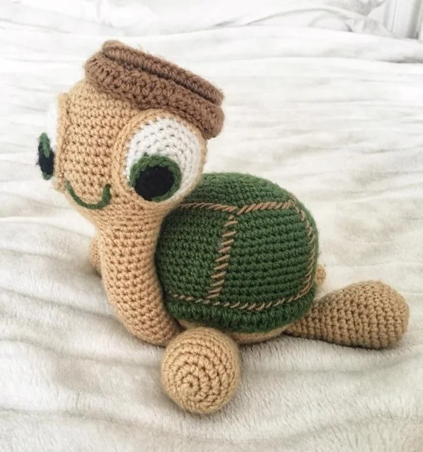 A long-necked crochet turtle with a cute facial expression.