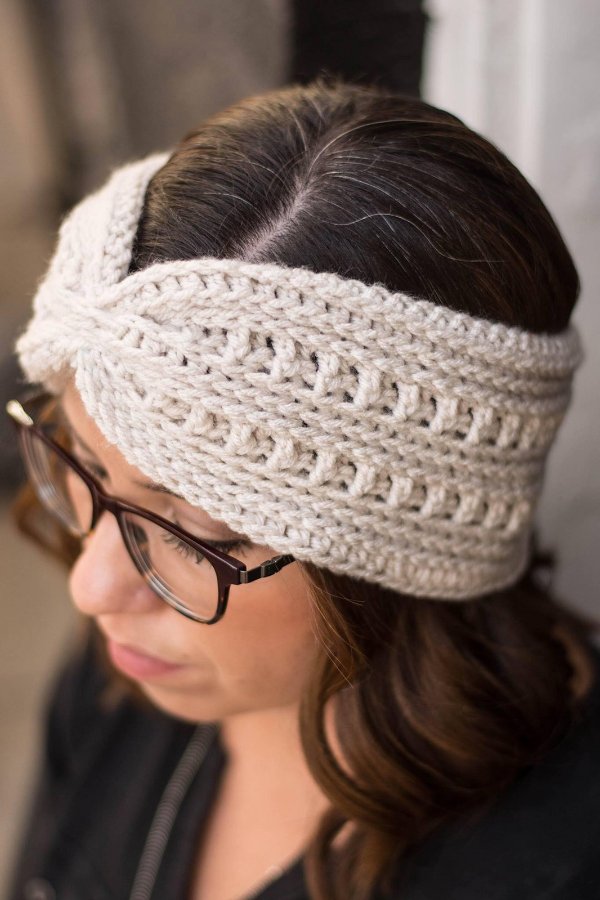a close-up view of a womand wering a textured crochet headband.
