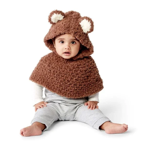 A baby wearing a hooded baby bear crochet poncho.