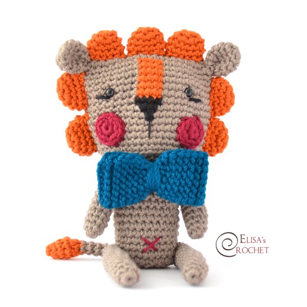A birghtly coloured crochet lion toy with a bow tie.