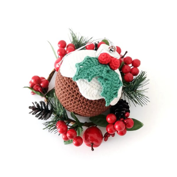 A crochet Chrismtas bauble made to look like a christmas pudding.
