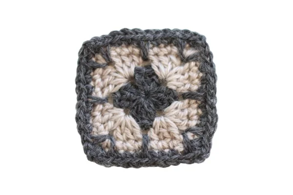 A close up image of a crochet granny square with a spike stitch border.