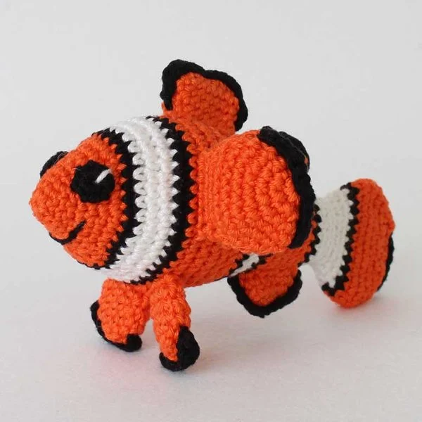 A brightly coloured crochet clownfish amigurumi.