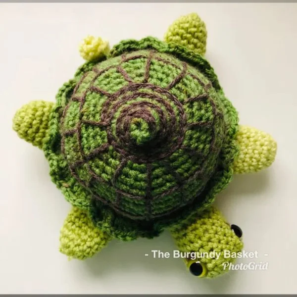 A top voew of a crochet turtle with embroidered shell detail.