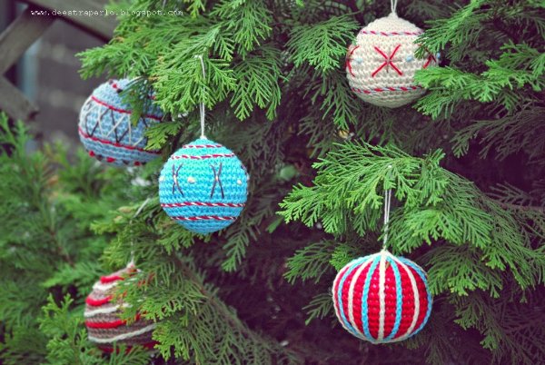 A close-up image of a Christmas tree decorated with crochet baubles.