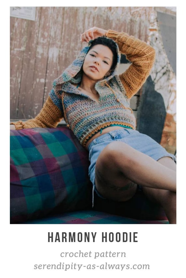 A woman wearing a cropped crochet hoodie.