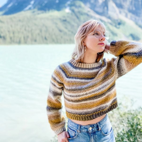 A young woman wearring a striped cropped crochet sweater.