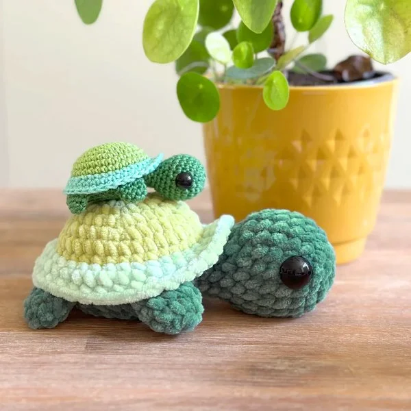 A mother crochet turtle and a baby crochet turtle.