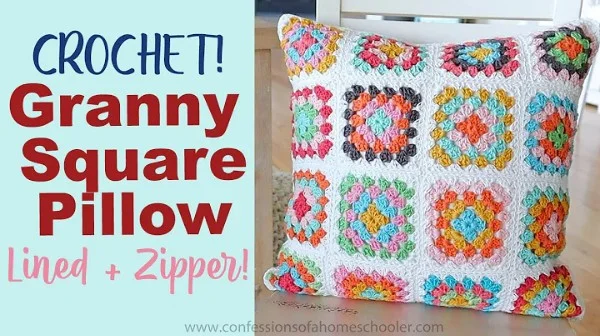 A crochet granny square pillow in brights and white.