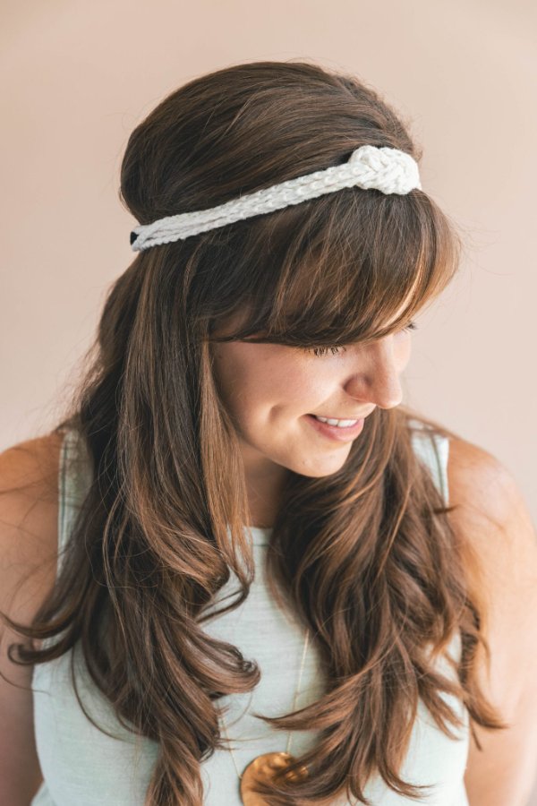 A white crochet headband with an infinity knot.