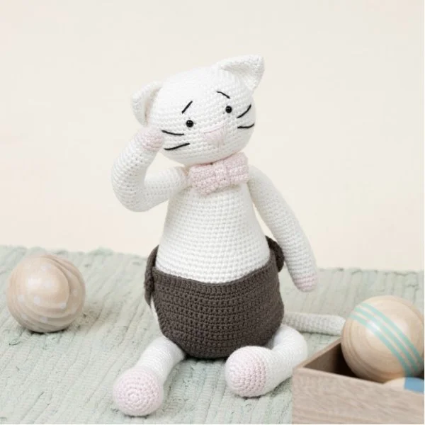 A white crochet cat toy wearing pants.