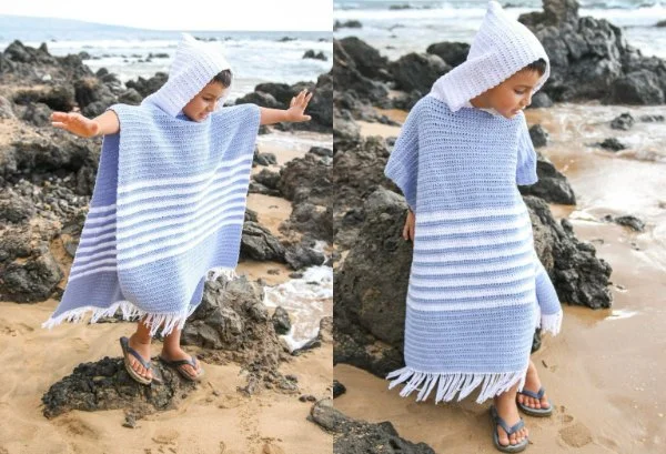 A child at the beach wearing a summer cotton crochet poncho with a hood.