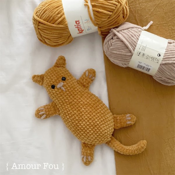 A mustard yellow crochet cat toy made with velvet chenille yarn.