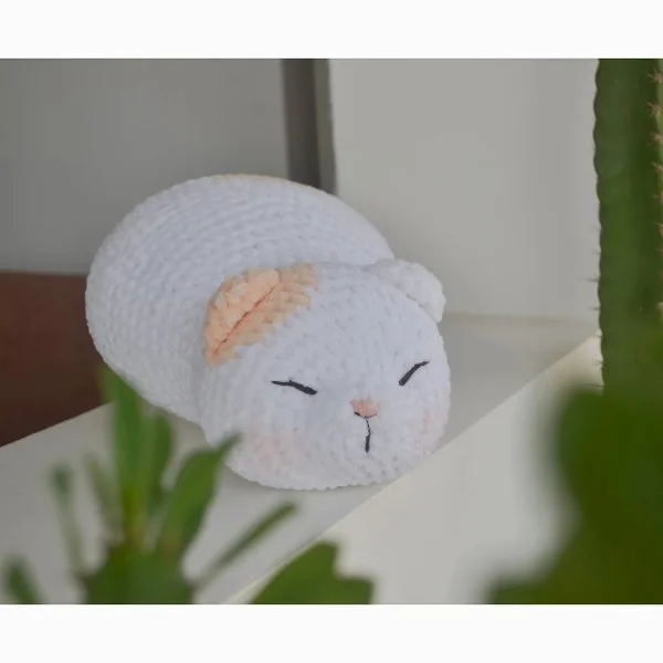 A fat crochet cat with a sweet facial expression.