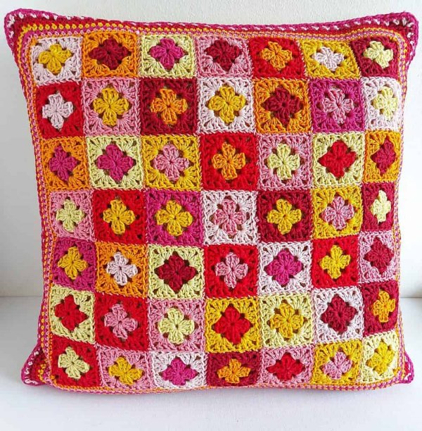 A crochet pillow made with mini granny squares.