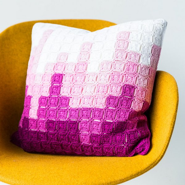 Crochet pillow with graphic skyline design made with granny squares.