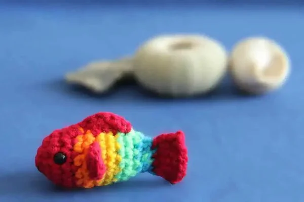 A tiny crochet rainbow fish.