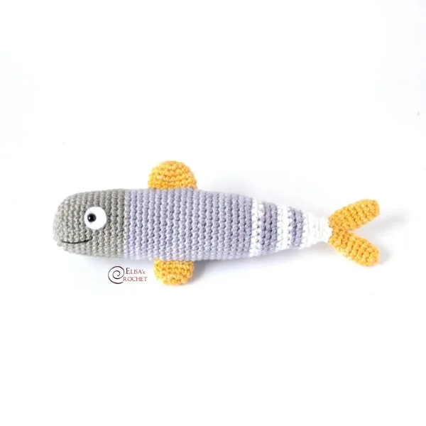 A long crochet fish with yellow fins and tail.