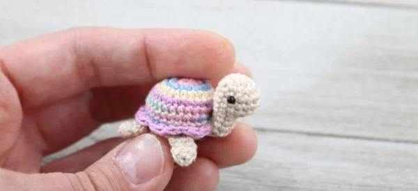 A tiny amigurumi crochet turtle.