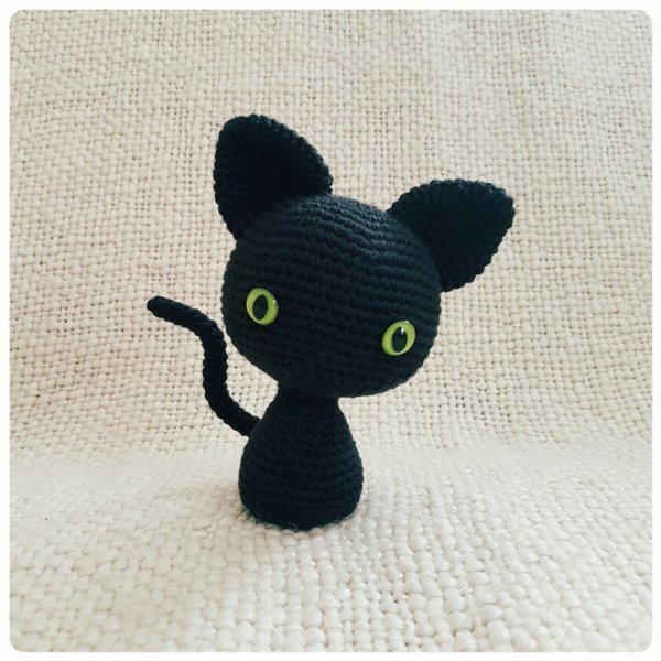 A black crochet cat with a large head.