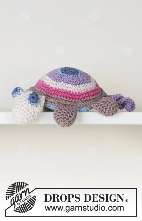 A crochet turtle with a multicoloured, striped shell.