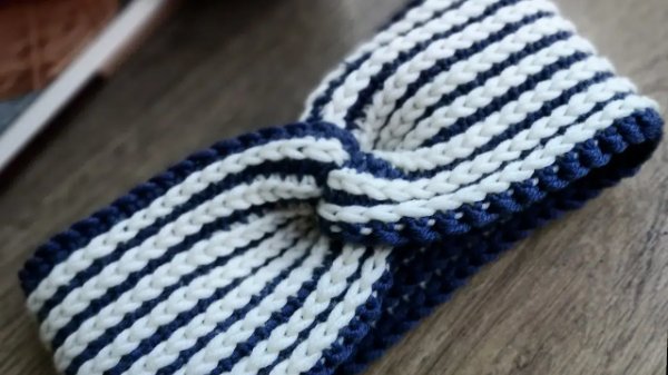 A c;ose-up view of a blue and white striped twisted crochet headband.