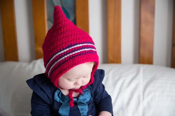 A baby boy wearing a crochet baby bonnet.