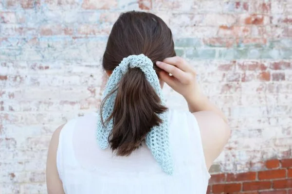 Back view of a woman wearing a crochet hair tie around her ponytail.